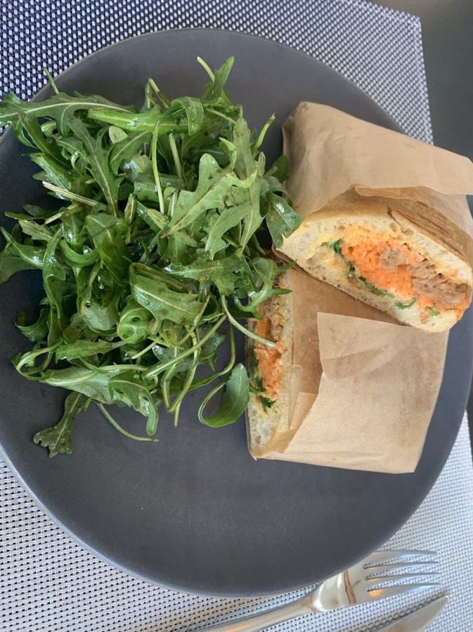 Sandwich dans son papier kraft avec salade de roquette